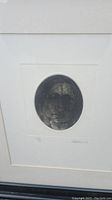 Close-up of oval portrait etching with visible artist signature and numbering