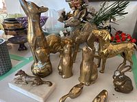 Group shot of all ten brass animal figurines on table.