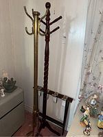 Full view of two coat racks and one luggage rack positioned together against a wall.