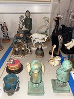 Overview of assorted figurines including people, birds, wildlife, and decorative objects.