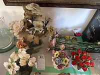 Overview of six floral figurines including ceramic flowers on stone bases with multiple colors