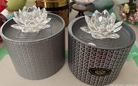 Two Swarovski crystal lotus flower candle stick holders in original round black boxes.