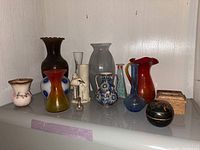 Full lot view showing a range of vases and trinket boxes arranged on a shelf