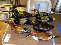 Five wood duck decoys arranged on table