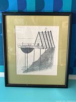 Full view of framed magazine print on black frame with green mat, showing entire artwork and frame in good condition with some dust.