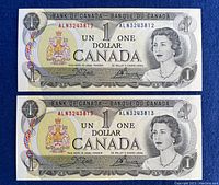 Two consecutive 1973 Canadian one dollar bills showing front side with Queen Elizabeth II portrait and Canadian coat of arms.