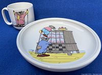 Full view of children's cup and bowl set showing the mouse design on both items on a blue background