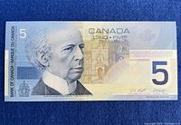 Front side of the Canadian $5 banknote featuring Sir Wilfrid Laurier and security details.