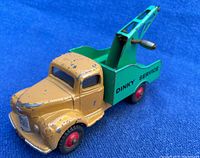 Front-left angled view showing yellow cab with chipped paint and green tow wrecker bed with red wheels