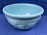 Side view showing turquoise glaze and raised pattern of Greek god Zephyrus blowing wind into ship sails.