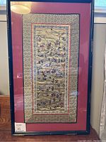 Full view of the framed embroidery panel showing layout and framing details.