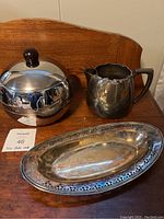Photo showing all three items: the chrome ice bucket, silver plate pierced tray, and water jug together on a wooden surface.