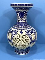 Front view of the assembled reticulated blue and white porcelain vase showing the floral cutout patterns and intricate blue design