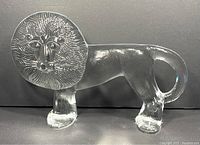 Side view of clear glass lion figurine showing the full length and detailed mane