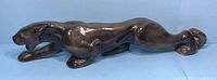 Side view of large ceramic black panther sculpture with glossy finish and streamlined body shape.