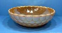 Side view showing bubble pattern and scalloped rim of peach lustre bowl