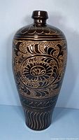 Front view of tall ovoid vase with narrow neck and carved floral decoration