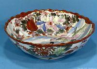 Front view showing scalloped rim and colorful floral hand-painted design.