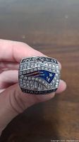 Front of the replica ring showing New England Patriots logo with 'WORLD CHAMPIONS' and rhinestones