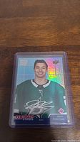 Jason Robertson rookie hockey card in a clear protective plastic sleeve showcasing holographic effects and printed autograph.