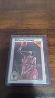 Photo of Michael Jordan 1990 SkyBox basketball trading card in protective plastic sleeve showing front of card with action image of Jordan in Chicago Bulls uniform.