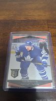 Front of Nick Robertson rookie hockey card in protective sleeve on wooden surface
