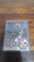 Front view of Shaquille O'Neal rookie basketball card in a plastic protective sleeve on wooden surface.