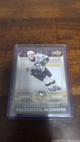 Photo of Sidney Crosby rookie card in protective case displaying limited edition number and player image.