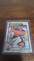 Clear image of Stuart Skinner rookie hockey card encased in plastic sleeve, featuring him in Edmonton Oilers goalie gear with team logos and 'Marquee Rookies' heading.