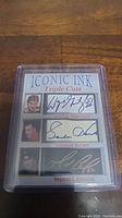 Front view of the Iconic Ink Triple Cuts card displaying three facsimile autographs by hockey players Wayne Gretzky, Gordie Howe, and Mario Lemieux inside a protective plastic case.
