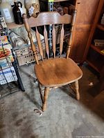 Single wooden kitchen chair without arms, showing its turned legs and backrest design