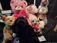 Front view of 7 assorted stuffed animals including teddy bear, rabbit, dogs, monkey and raccoon
