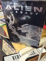 Front view of shrink-wrapped boxed DVD set showing embossed Alien creature and The Alien Legacy title.