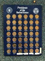 Full view of the set of 42 bronze commemorative president coins mounted on a blue display card titled 'Presidents of the United States' with presidential seals.