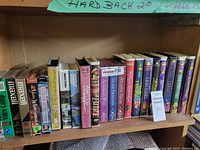 Shelf with VHS tapes including Disney movies and travel titles, showing spines and cover labels.