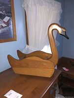 Wooden duck magazine holder side view showing carved head and smooth wooden body.