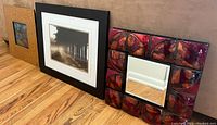 Framed pieces and decorative mirror resting on the floor showing all 3 items.