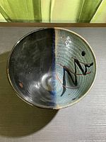 Top view of the bowl showing interior design with two-tone glaze and abstract marks.