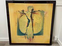 Framed abstract relief artwork with two textured human figures and concentric background circles.