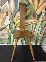 Front view of the Ashford spinning chair showing the contoured wooden seat and turned legs.