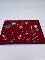 Full display of assorted vintage and costume jewelry lot arranged on red cloth background