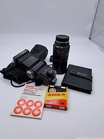 Overall view of flash, lens, filter box, manual, pouch and album