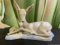 Front angle showing the sitting doe and fawn with naturalistic painted detailing and smooth glaze finish.