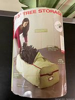 Packaging showing image and features of the 7.5' Christmas Tree Storage Bag including zipper access, reinforced handles, built-in roller wheels, and label holder