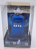 Front view of the ornament in original clear display box showing blue Police Public Call Box design.