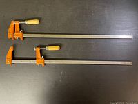 Overhead view of both F-clamps showing their full length and condition.