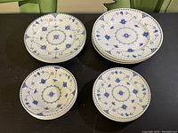 Top view showing multiple stacked plates of different sizes with blue floral pattern on white porcelain.