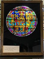 Frontal view of the framed miniature stained glass panel showing the full colorful scene behind glass.