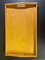 Top-down view of a rectangular wooden tray showing smooth surface and slight wear.