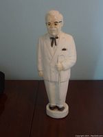 Front view of vintage Colonel Sanders bank in white suit holding cane.